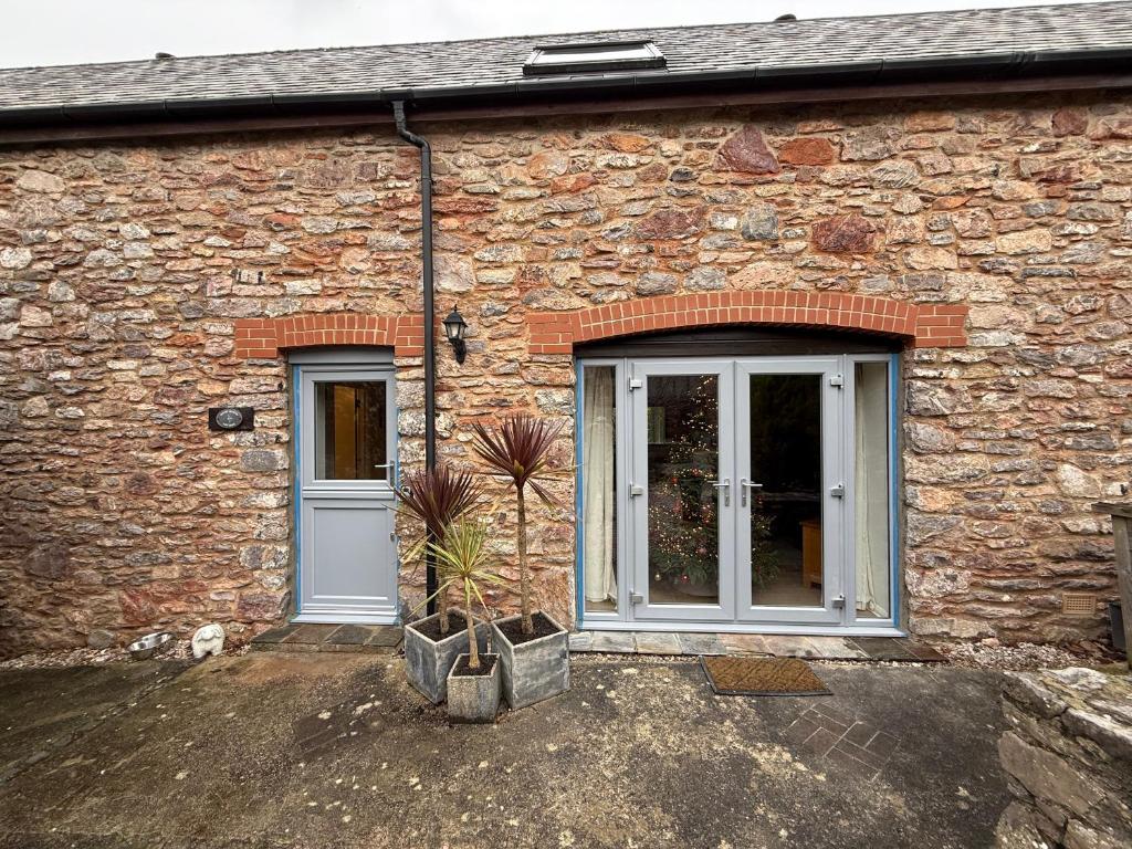 a brick building with a door and a potted plant at House Martin in Ipplepen