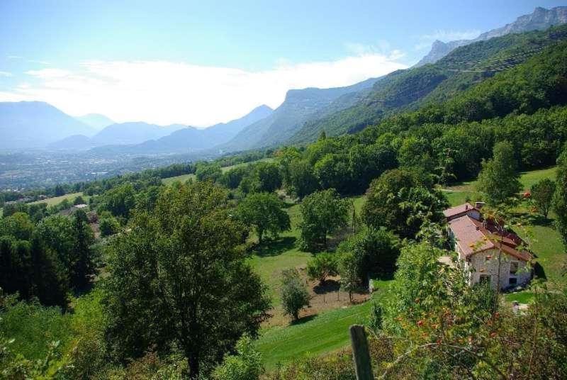 a house in a field with mountains in the background at Gîte la Planta de Cossey 2 in Claix