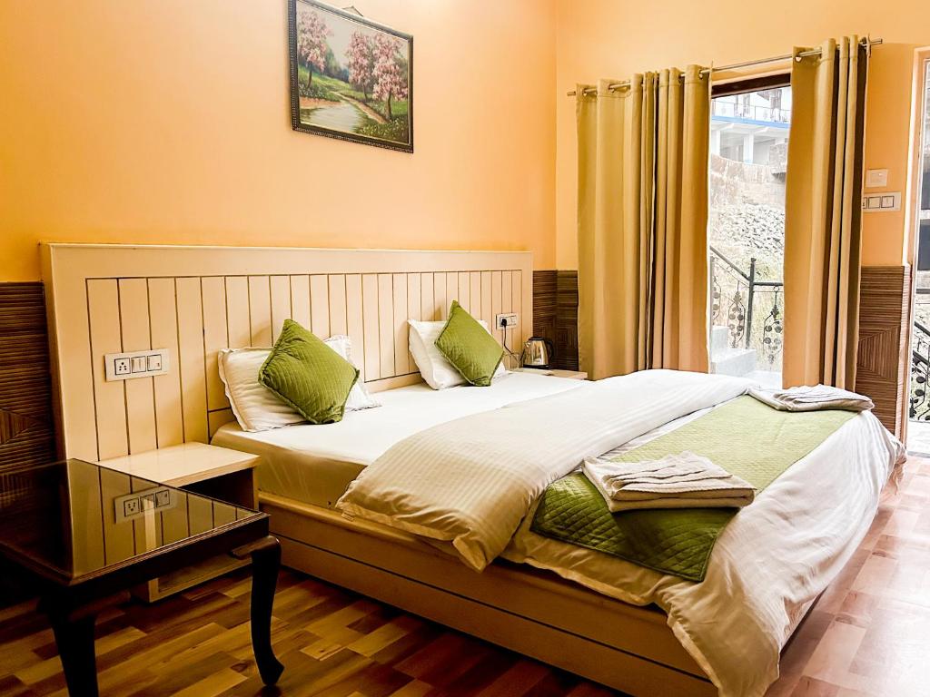 a bedroom with a bed with green pillows and a window at Vacation home in Dharmsāla
