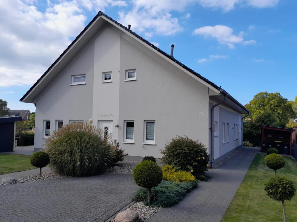 a white house with a driveway at Ferienhaus Seeschwalbe in Fehmarn