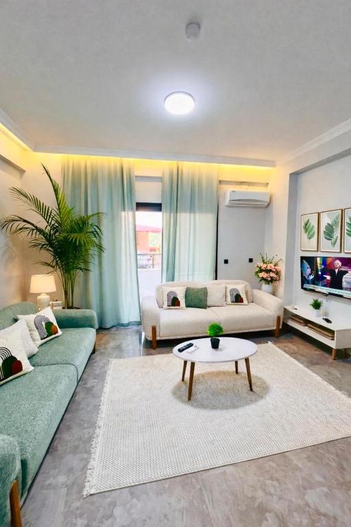 a living room with two couches and a table at Arsuz Suit in Hatay