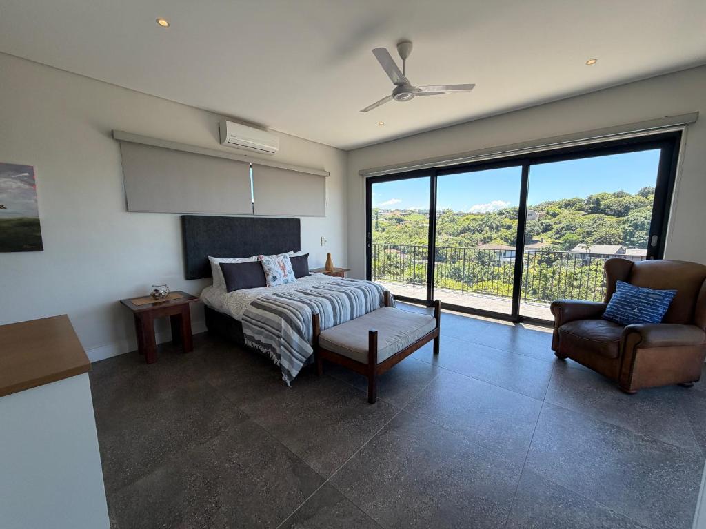 a bedroom with a bed and a large window at Parrotfish Room in Ballito