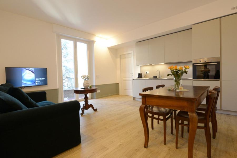 a living room with a table and a kitchen at LA FORESTERIA Case a Varese in Varese