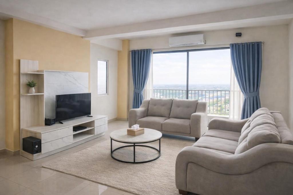 a living room with a couch and a television at Starlight Homestay The Venus Sitiawan in Seri Manjung