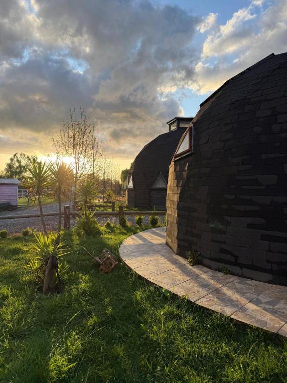 a brick building with a grassy field and a building at Domo Familiar Mi Espacio Rustiko in San Carlos