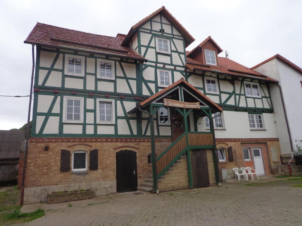 ein altes Haus mit einer Treppe davor in der Unterkunft Ferienwohnung Valora in Obergude