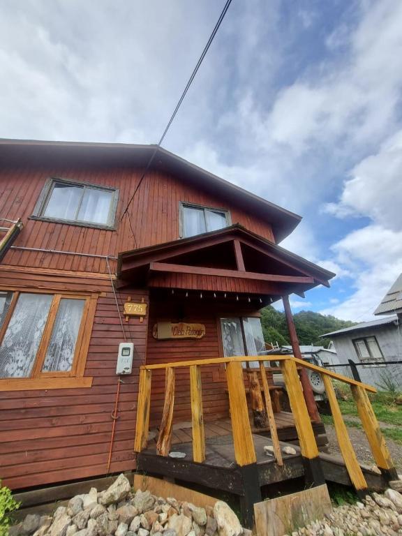 a log cabin with a porch and a house at Cabaña Cielo Patagonico in Futaleufú