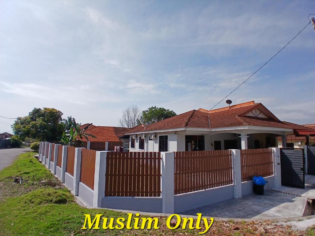 a house with a fence in front of it at Homestay Makyu Kuala Kangsar in Kuala Kangsar