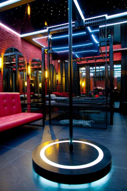 a room with a red couch and a bench and a table at Love Apartament z sauną i jacuzzi in Katowice