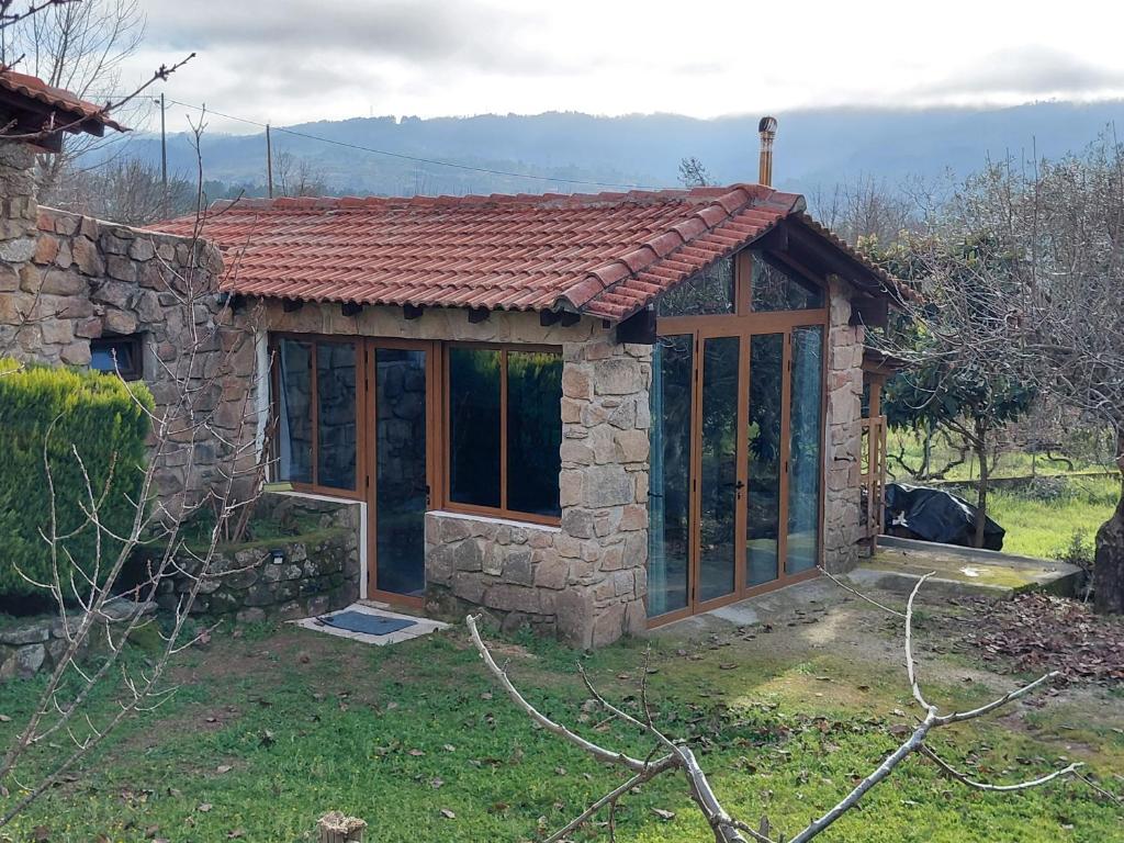 a small stone house with a red roof at Quinta da Portela in Ferro