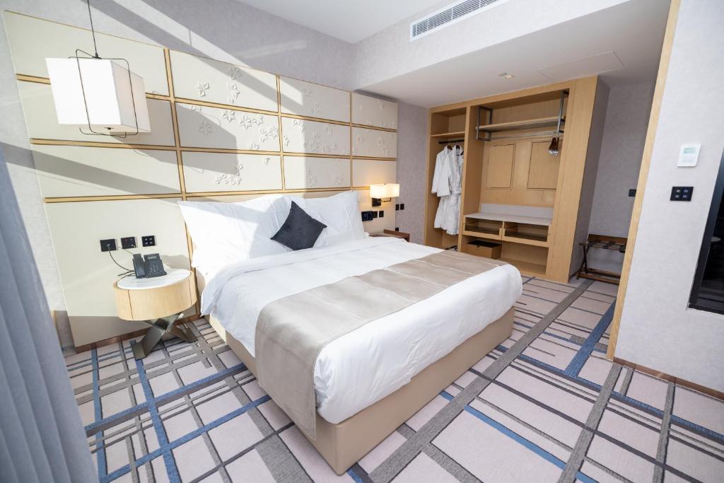 a bedroom with a large white bed in a room at 7Crown Tahliah Hotel in Riyadh