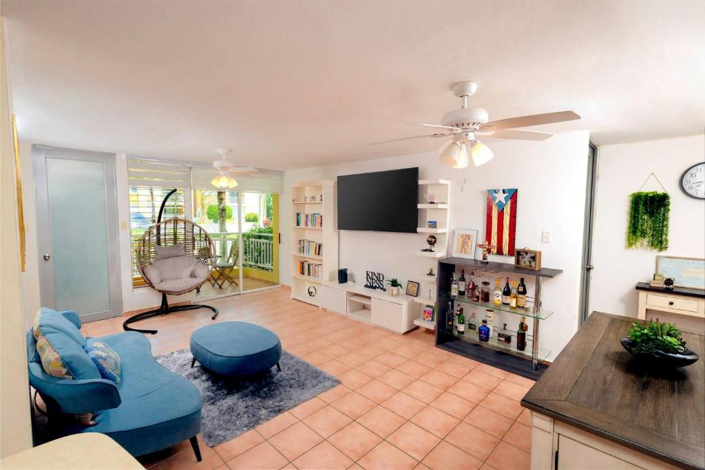 a living room with a tv and a couch and a chair at Beach condo with 3 bedrooms and ocean views in Rio Grande