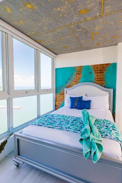 a bedroom with a bed with a blue ceiling at Ocean view condo with pool & fits 3 in Fajardo