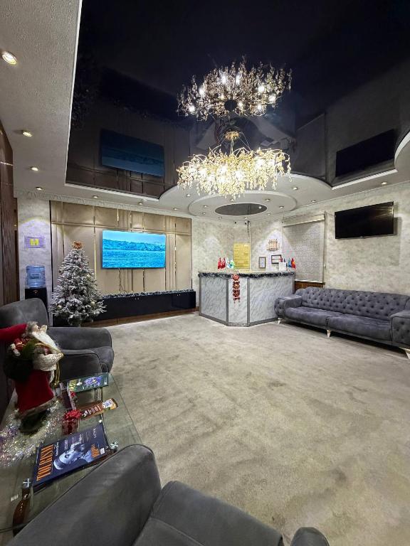 a large room with couches and a christmas tree at Nur m hotel Free transfe hotel in airoport in Yakkasaray