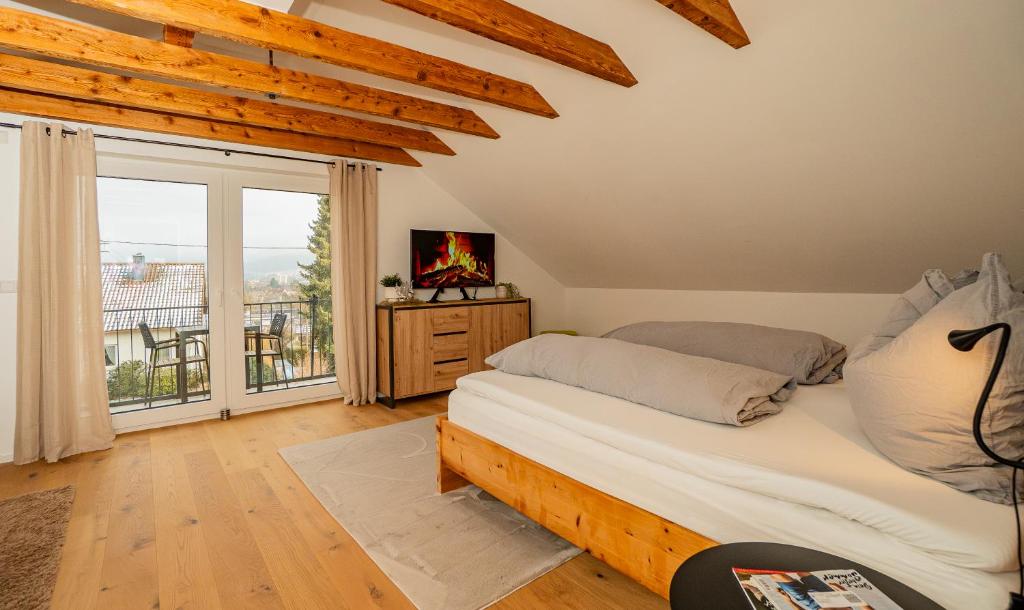 a bedroom with a bed and a large window at Alb Appartement - gemütliche Wohnung mit Balkon in Balingen
