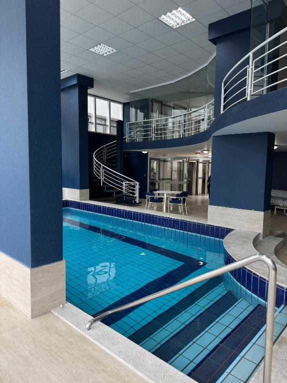 ein großes Schwimmbad in einem Gebäude mit blauen Wänden in der Unterkunft Hotel Blumenau by Pires - Balneário Camboriú in Balneário Camboriú
