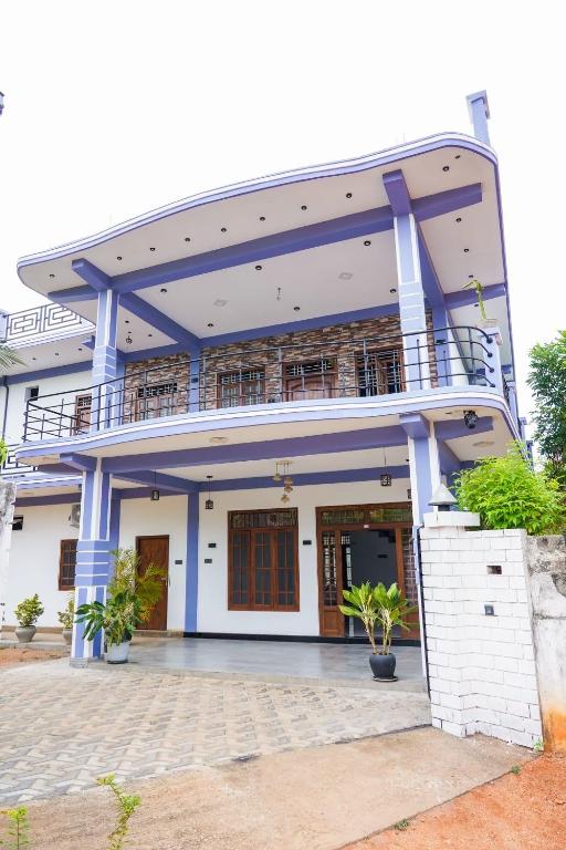 a building with a balcony on top of it at RKM Hotel Uppuveli in Trincomalee