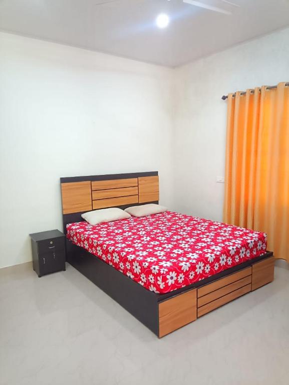 a bedroom with a bed with a red bedspread at Spring Dale Homestay in Thekkady