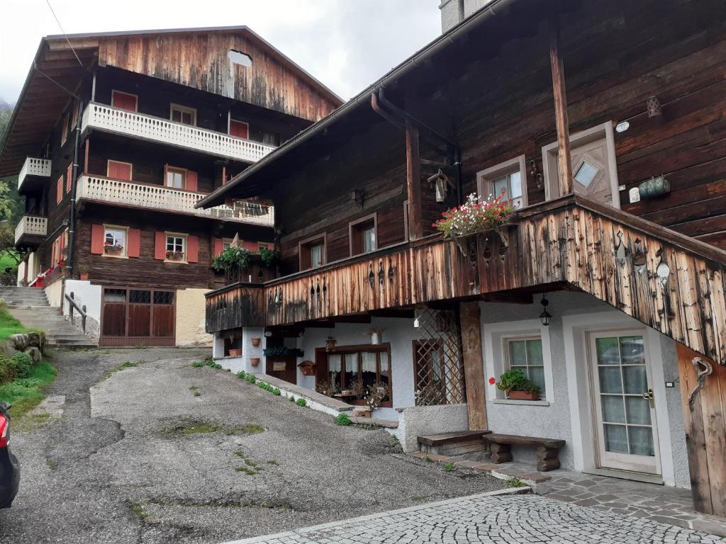an old wooden building with flowers on the balcony at Casa Milpa in Sappada