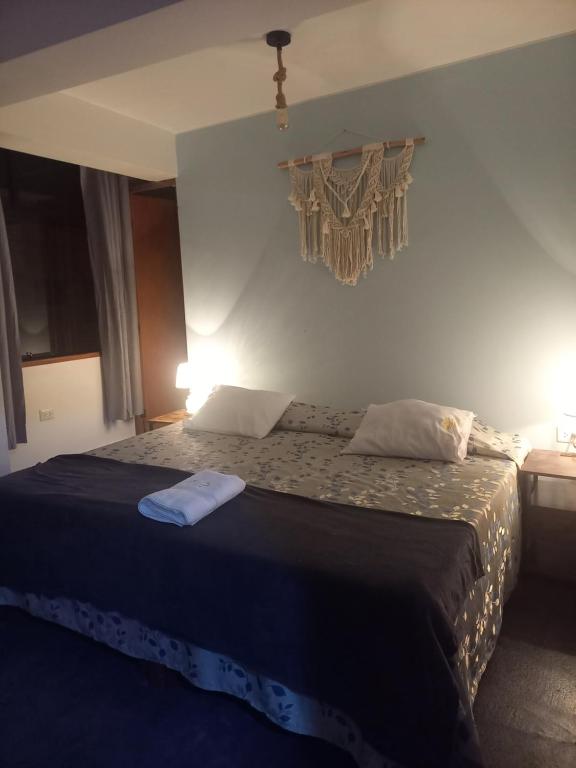 a bedroom with a large bed with a blue blanket at Hospedaje Velilu in Ica