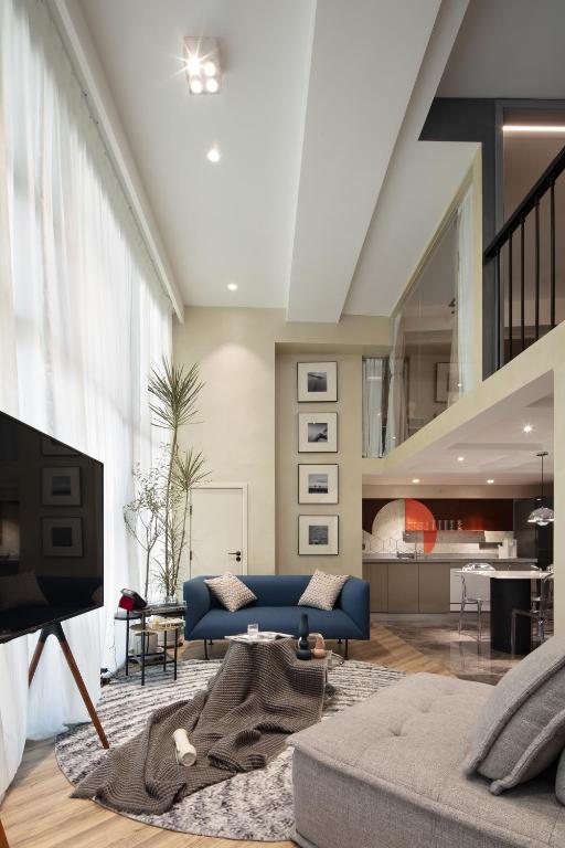 a living room with a blue couch and a tv at ChangSha YunXi Riverview Hotel in Changsha