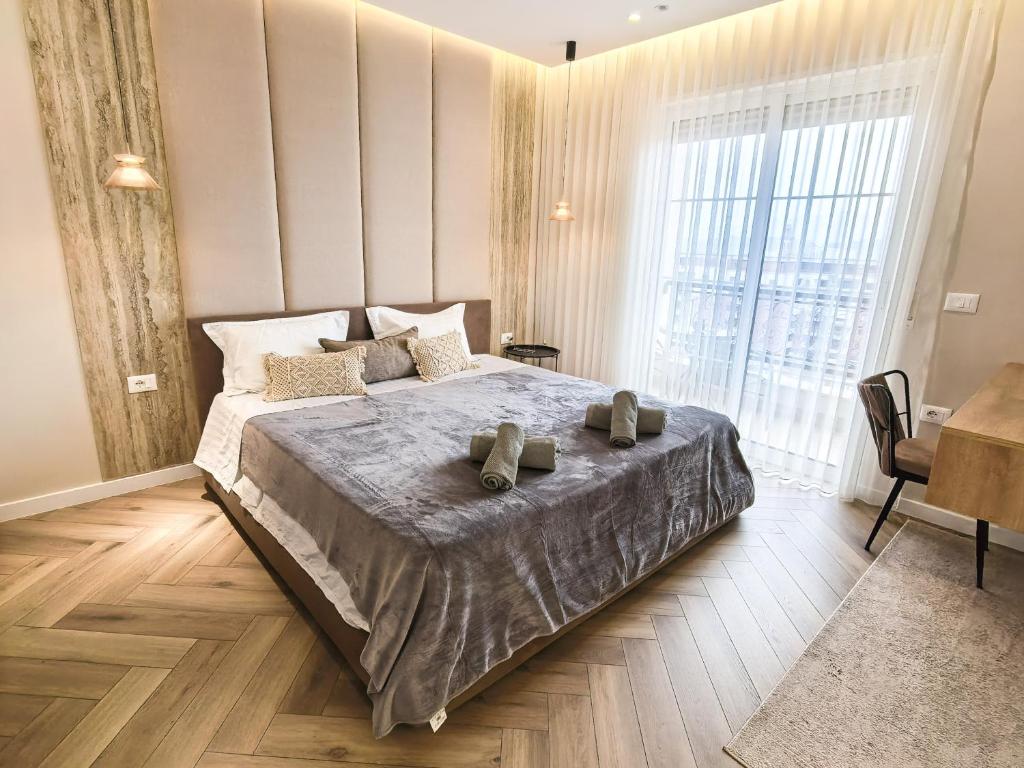 a bedroom with a bed with two shoes on it at Downtown Shkodra Apartment in Shkodër