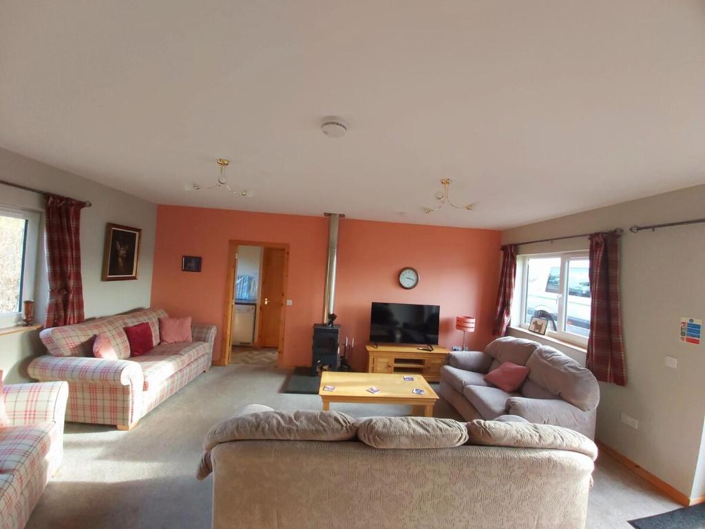 a living room with two couches and a tv at Roe Deer Cottage in Beauly
