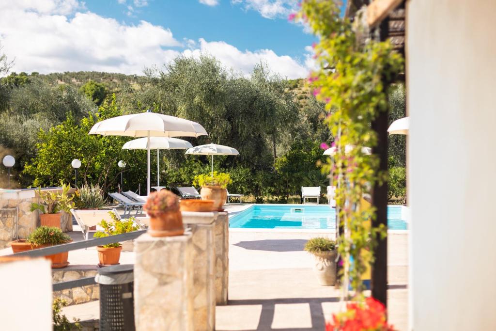 a swimming pool with two umbrellas and a pool at Agriturismo Azzarone in Vieste