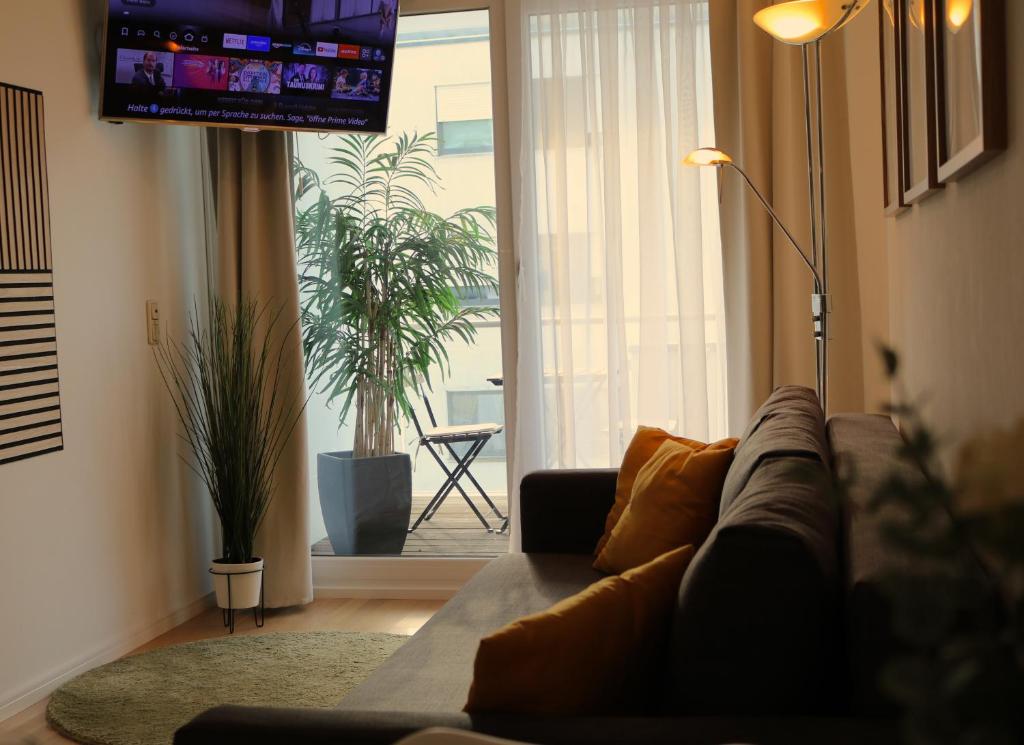 a living room with a couch and a flat screen tv at DUTTI'S HOME - 1 Zimmer Apartment, Küche, Self-Check-in, Stellplatz in Ingolstadt