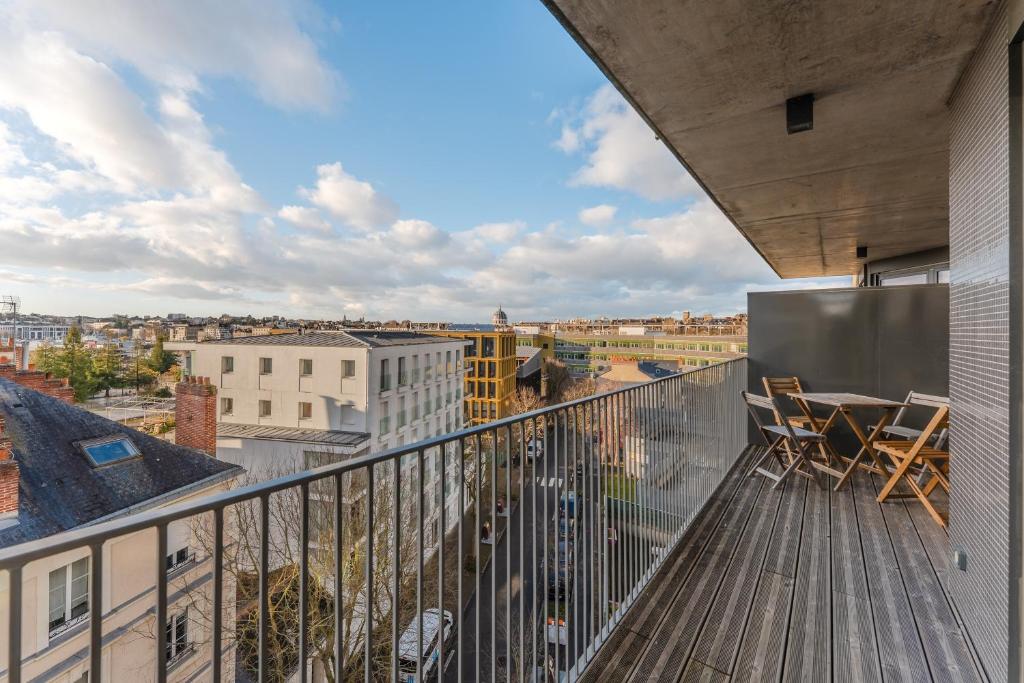 a balcony with chairs and a view of a city at Dumbo - Île de Nantes in Nantes