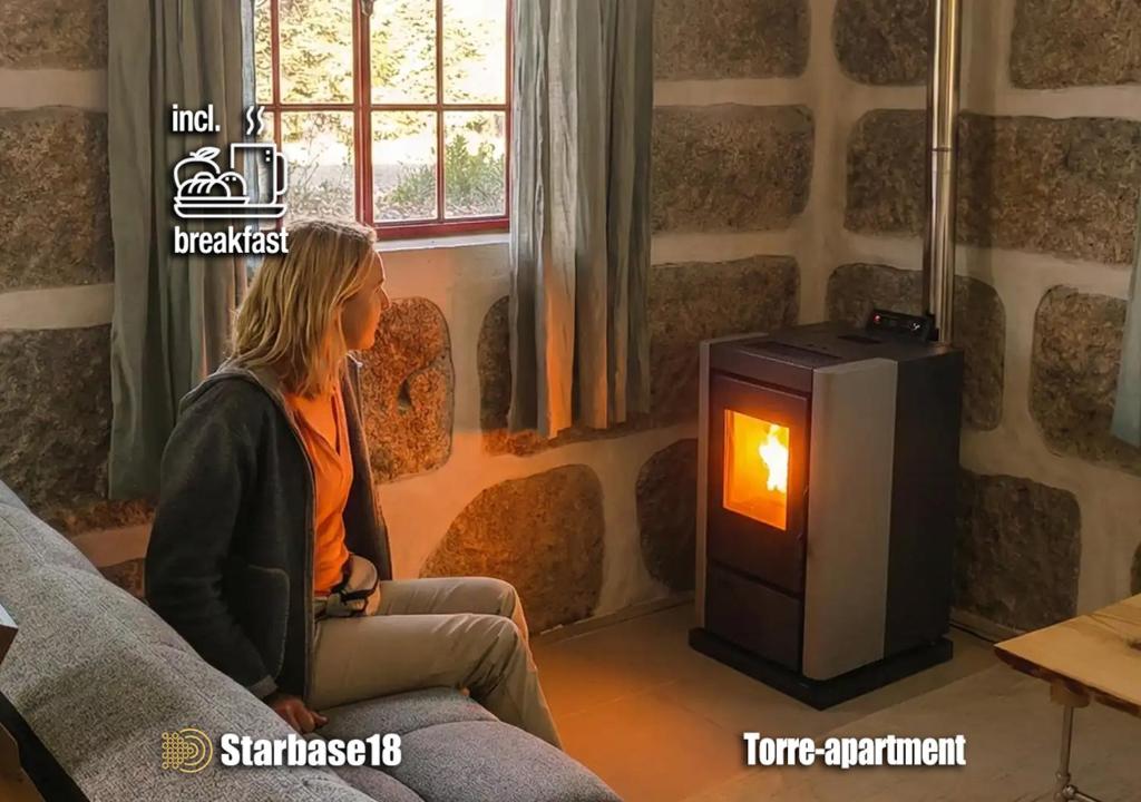 a woman sitting on a couch next to a stove at Starbase18 lda Ecotourism in Fernão Joanes