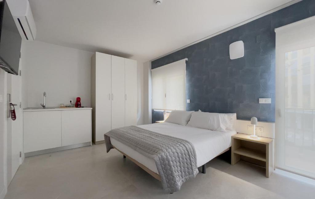 a bedroom with a bed with a blue accent wall at 6 de Mayo alojamientos in Almansa