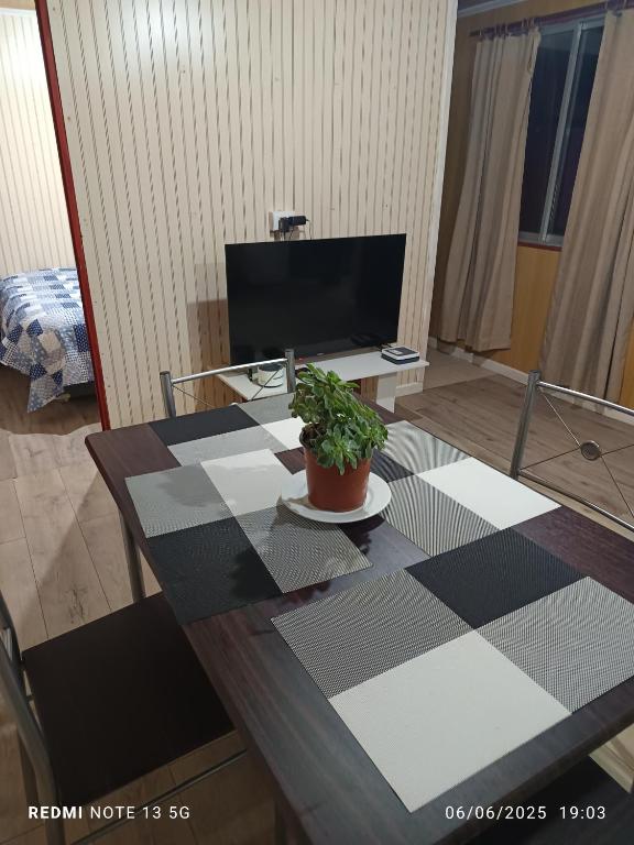a living room with a table with a potted plant on it at Casa en arriendo in Quintero