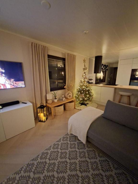 a living room with a christmas tree and a bed at Villa Juhala in Rovaniemi