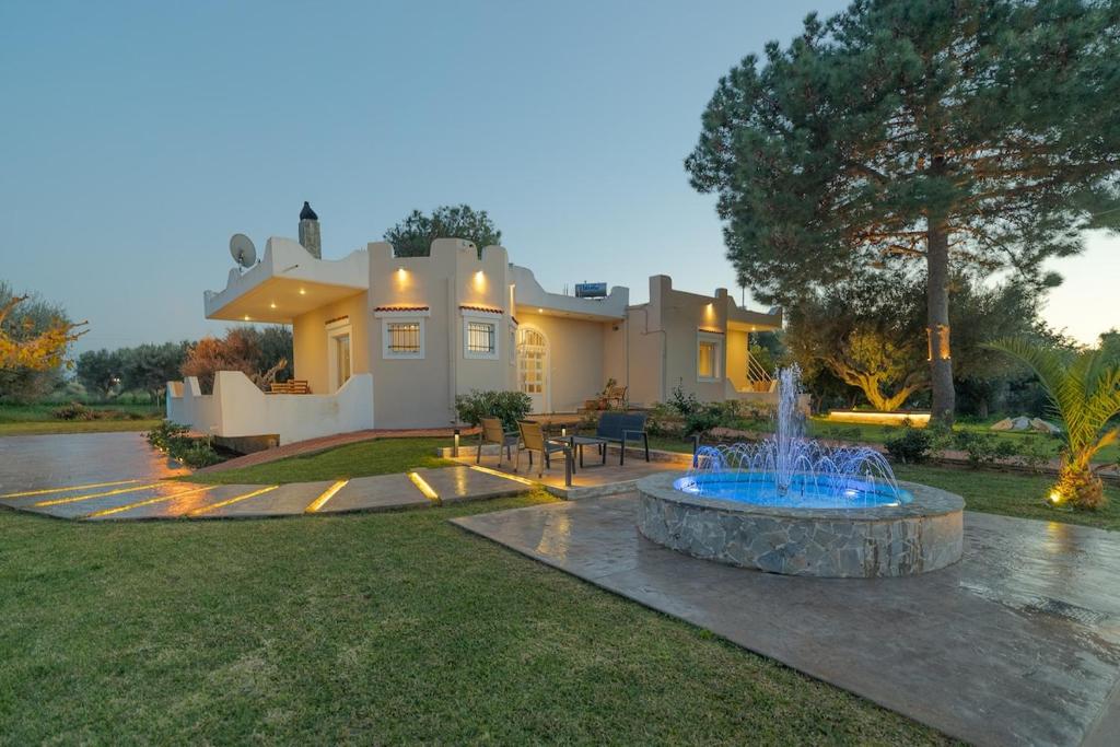 a large house with a fountain in front of it at Villa Antheon in Kalamákion