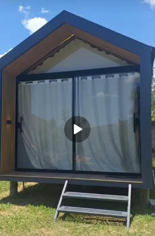 a large window in a tiny house with a bench at Chalé Loft in Lavrinhas