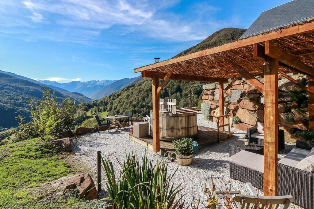 a wooden pavilion with a hot tub on a mountain at Appartement vue panoramique in Binos