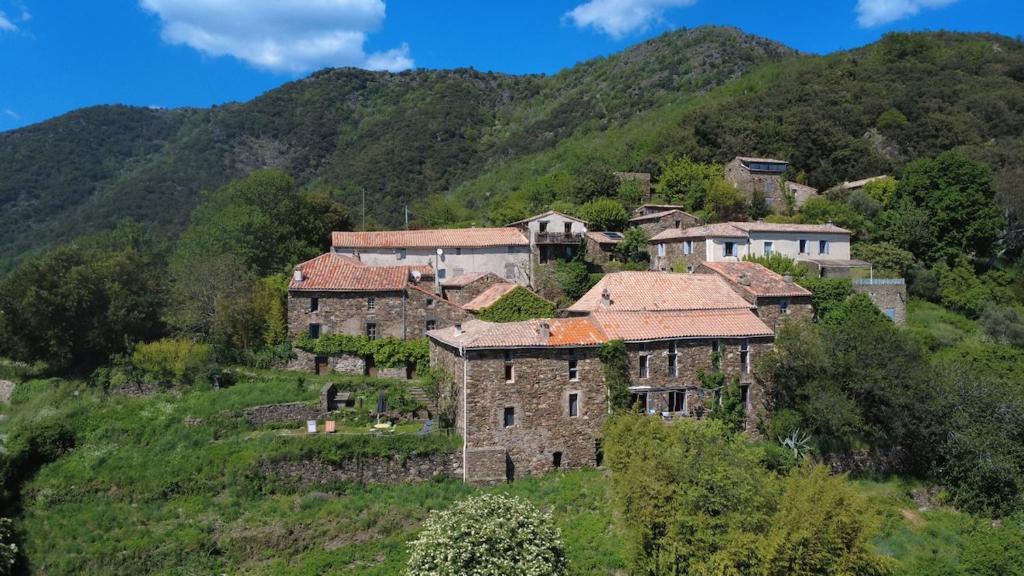 a group of houses on a hill in the mountains at Le Châtaignier in Faveyrolles