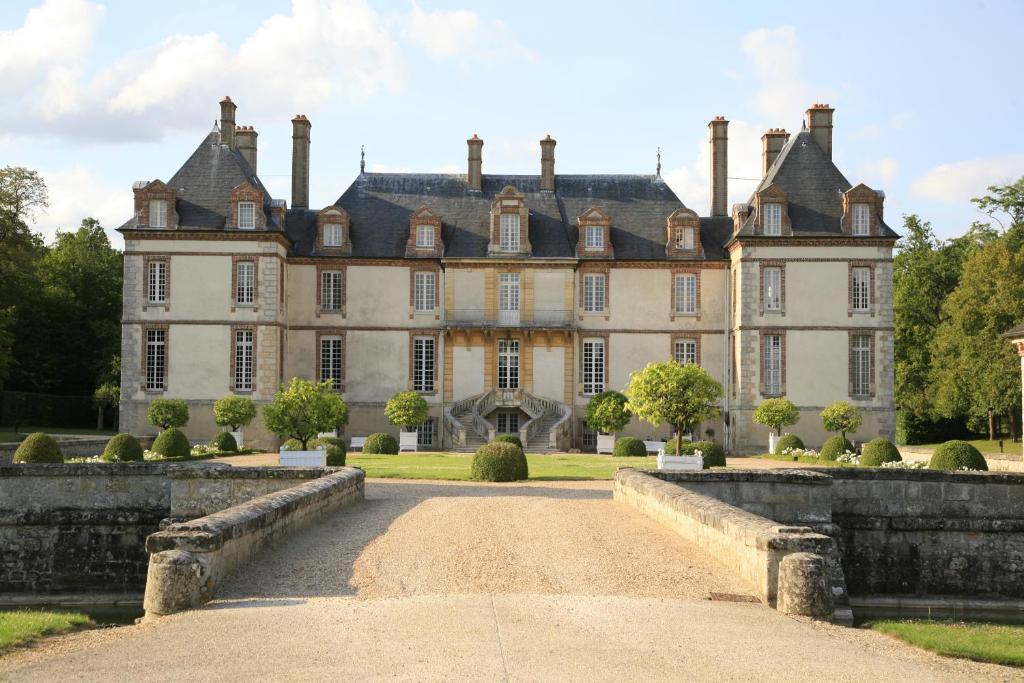 een oud herenhuis met een brug ervoor bij Château-Hôtel de Bourron in Bourron-Marlotte
