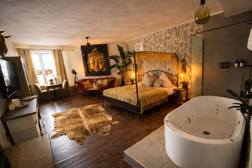a bedroom with a bed and a tub in a room at Ferienwohnung Time out in Vreden