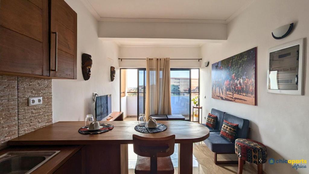 a kitchen with a table and a dining room at Chic studio with parking & balcony in Yaoundé