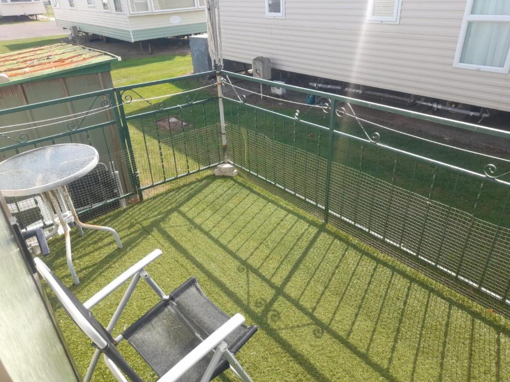 a bird cage with chairs and a table on a porch at T & L CARAVANs in Skegness