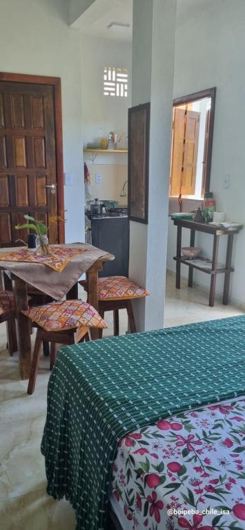 a room with a table and chairs and a kitchen at Boipeba casa de un ambiente in Cairu