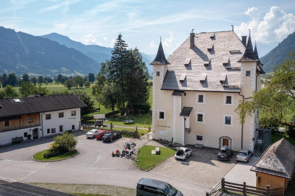 an aerial view of a castle with cars parked in a parking lot at Schloss Saalhof- Schlossflair, Wellnessauszeit, Bauernhofleben, Familienzeit im historischen Apartment zentral zwischen Zell am See und Saalbach-Hinterglemm in Maishofen