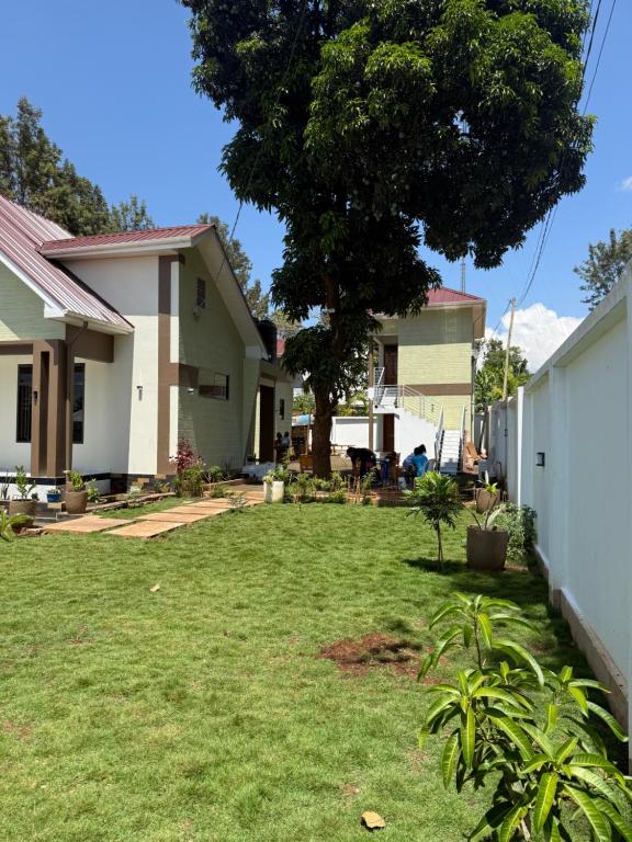 a yard with a house and a tree at Safari Haven Villa in Moshi