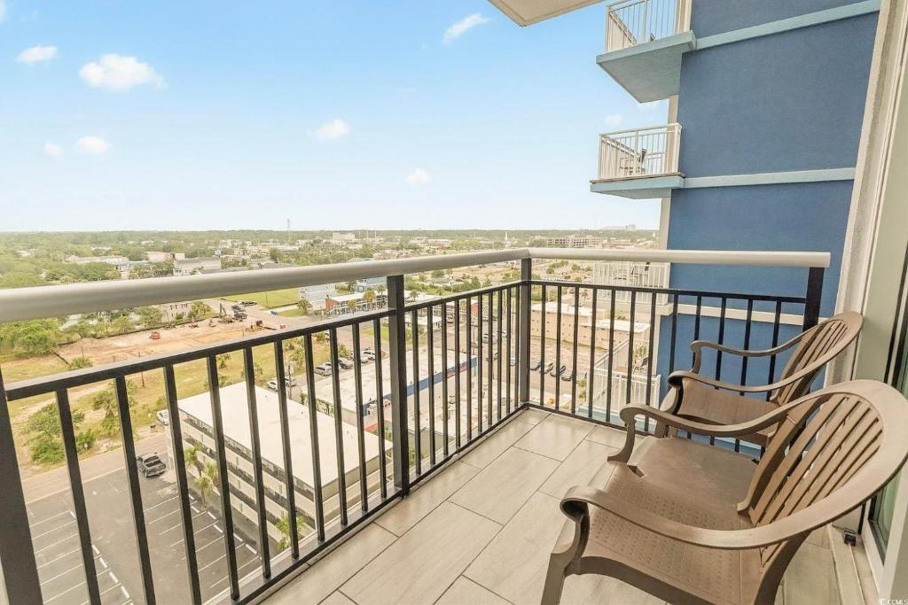 a balcony with two chairs and a view of the city at Bay View Resort 1202 in Myrtle Beach
