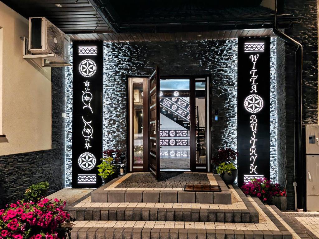 an entrance to a building with stairs and flowers at Willa Bustryk in Bustryk