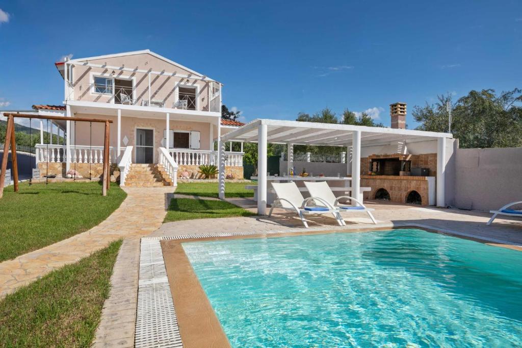 a house with a swimming pool in front of a house at Villa Anastasis in Halikounas