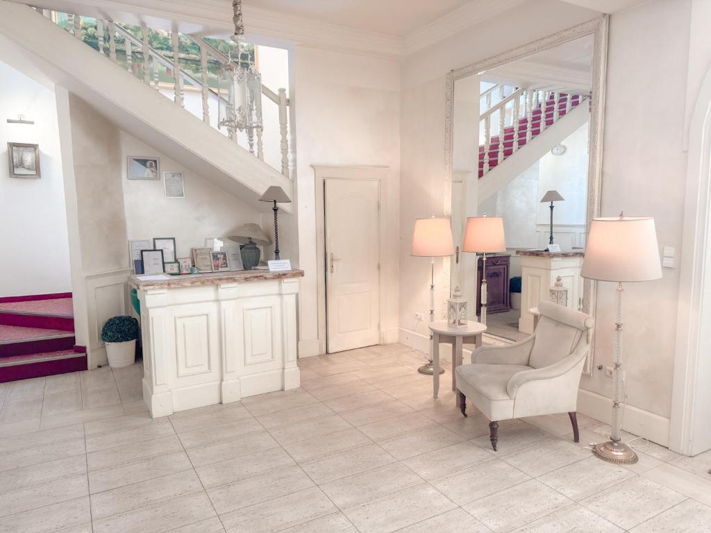 a living room with a staircase and a chair and a mirror at Złote Runo - Kameralny hotelik & Restauracja in Karolina