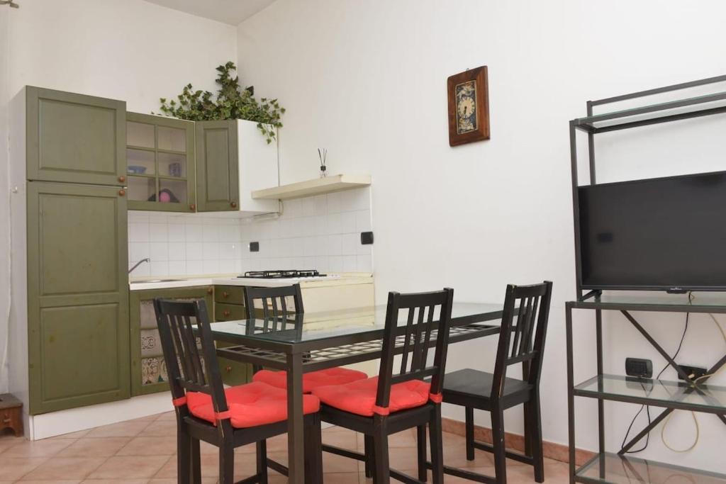 a kitchen with a table with chairs and a tv at Central apartment in Arluno